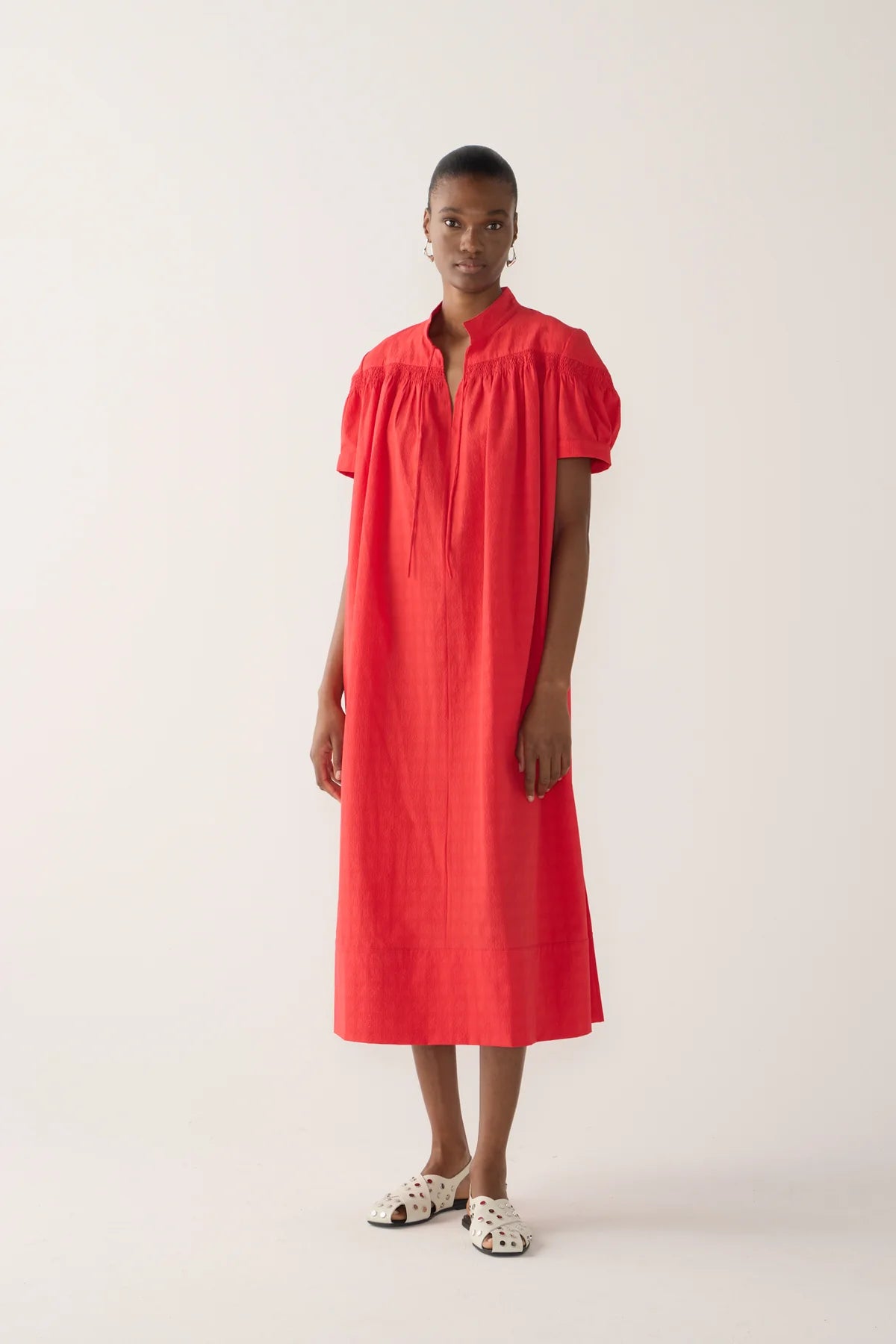 Model wearing Kaya Dress from Foemina. rouge seersucker, with cap sleeve, rusching details across shoulder seam, self tie at front neck, tick hem detail.