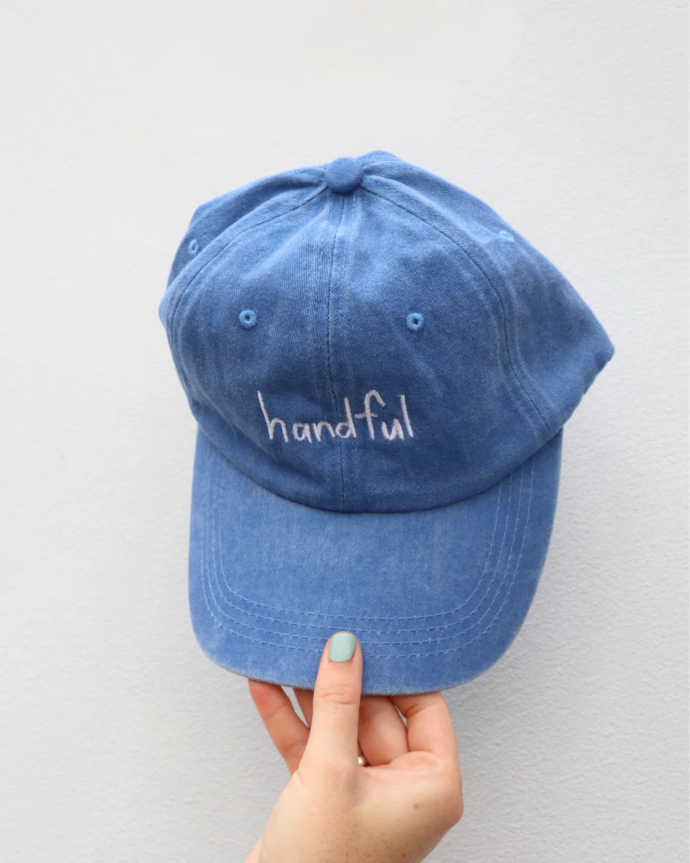 Blue cap with white “handful” text made from cotton