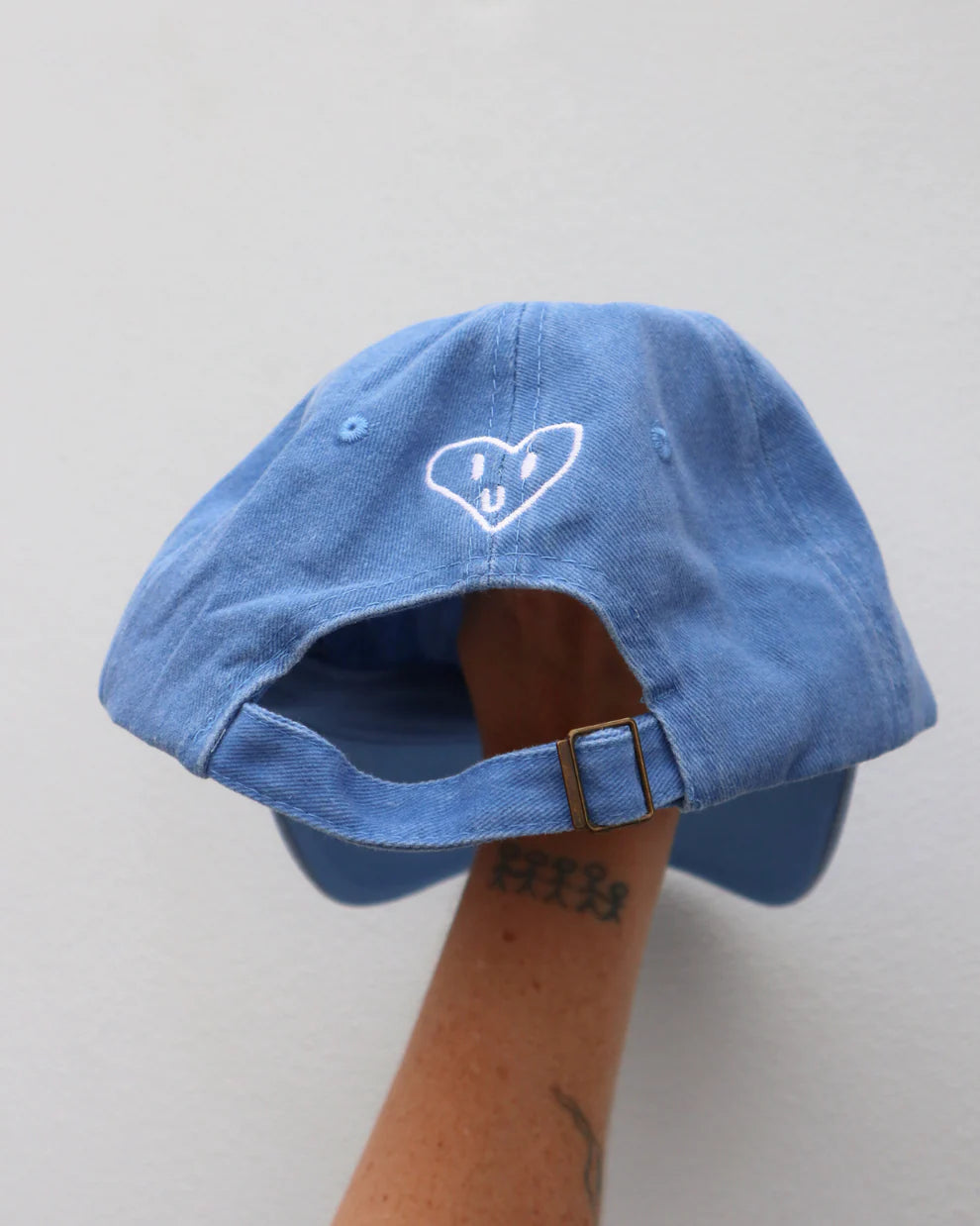 Blue cap with white “handful” text made from cotton