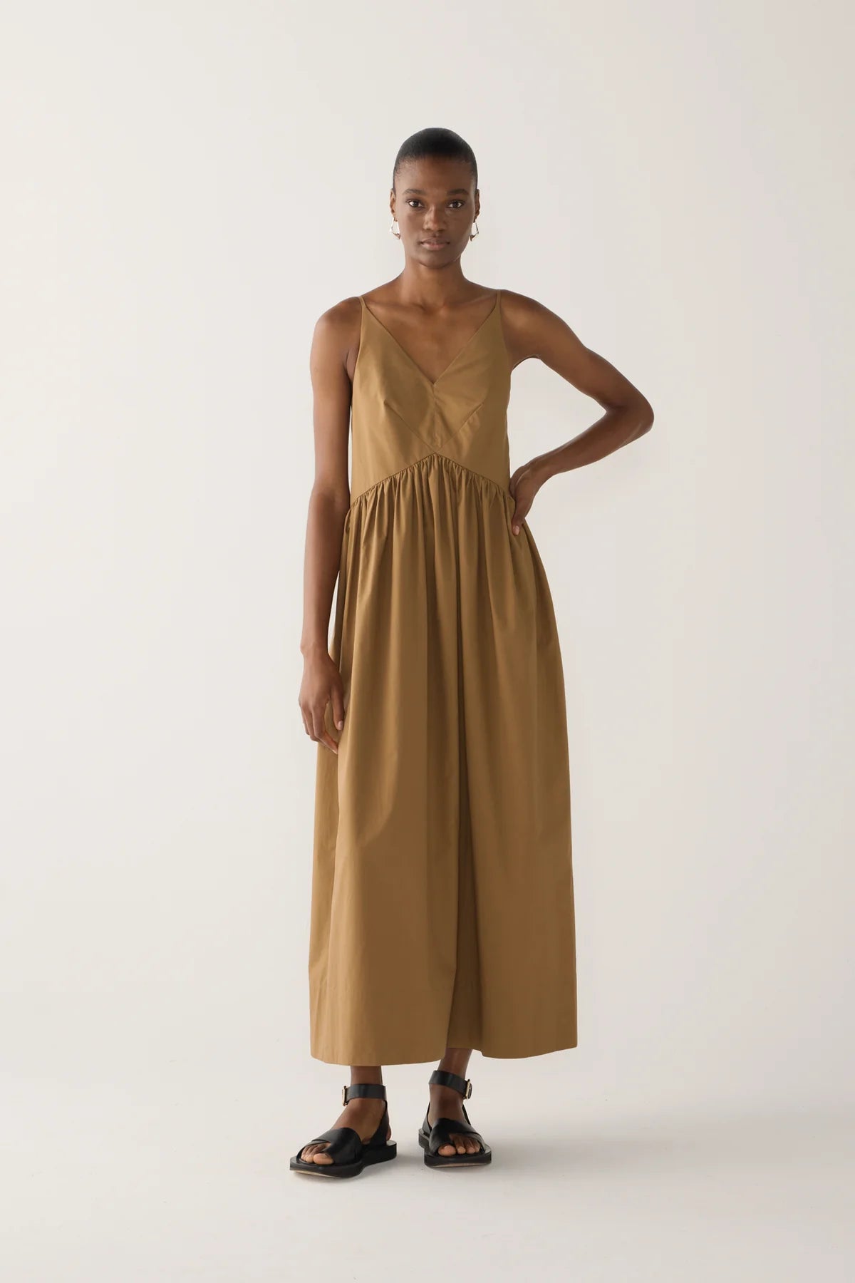 Model wearing Amanda dress from Foemina. Cocoa cotton tencel spaghetti strap dress with gathering at bodice seam, adjustable straps, side seam pockets and bodice seam details