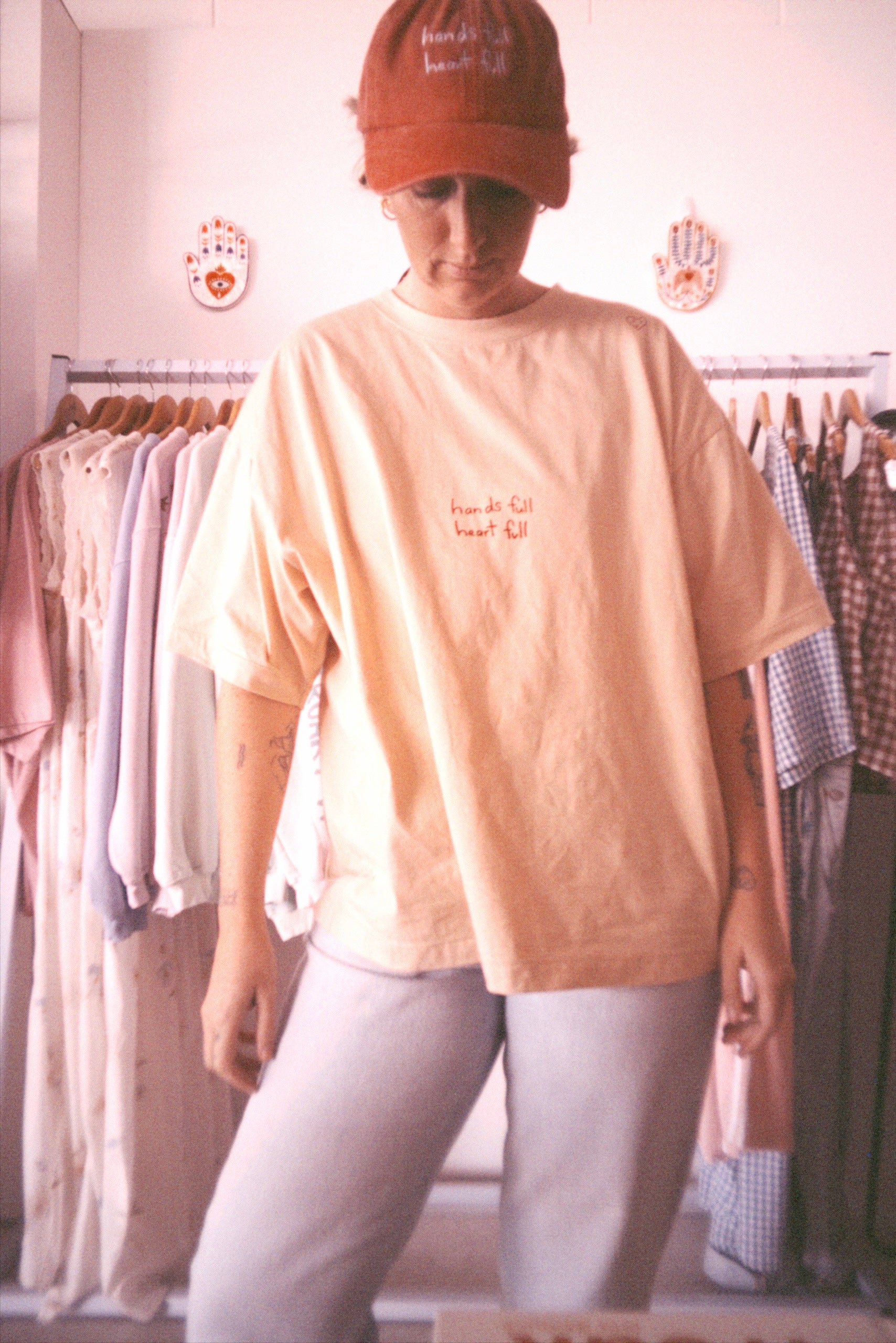 Red cap with pink “hands full heart full” text made from cotton