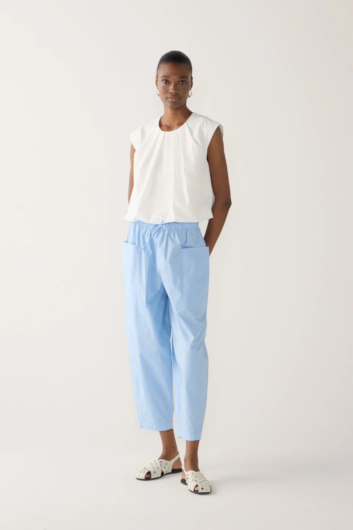  Model wearing chambray cropped barrel leg organic cotton poplin pants with a drawstring waist and front patch pockets