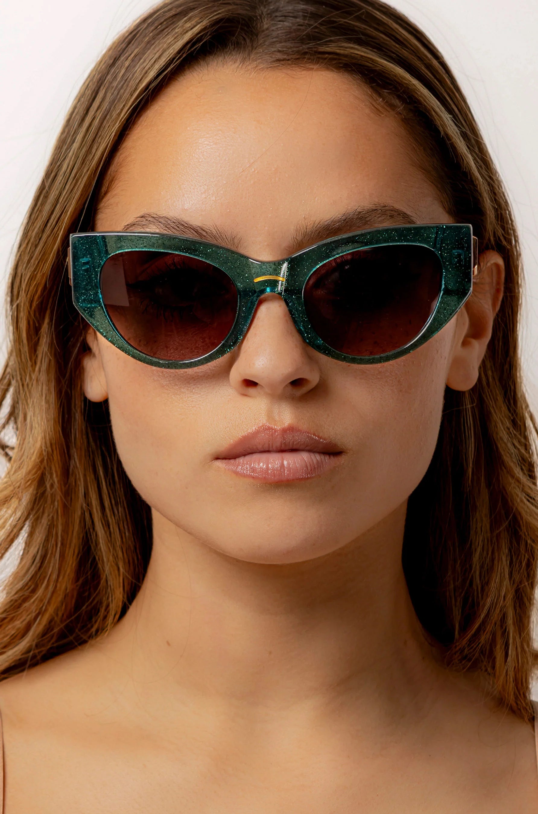 Woman wearing green almond shaped sunglasses in green shimmer acetate