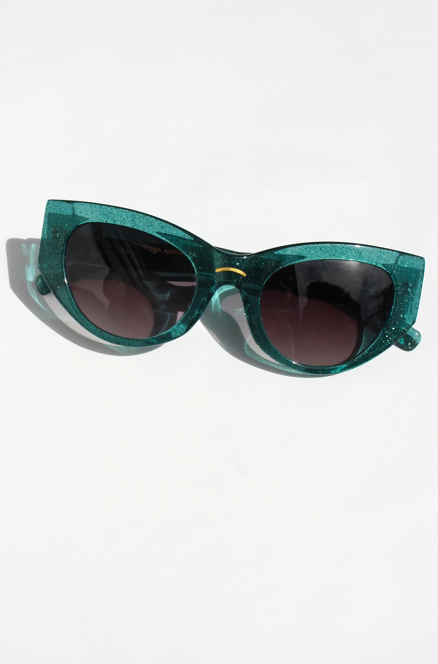 Woman wearing green almond shaped sunglasses in green shimmer acetate