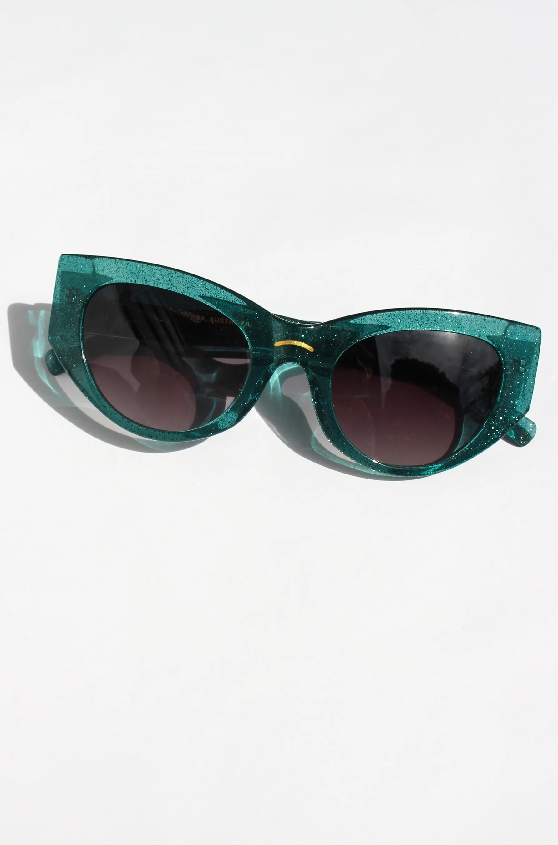 Woman wearing green almond shaped sunglasses in green shimmer acetate