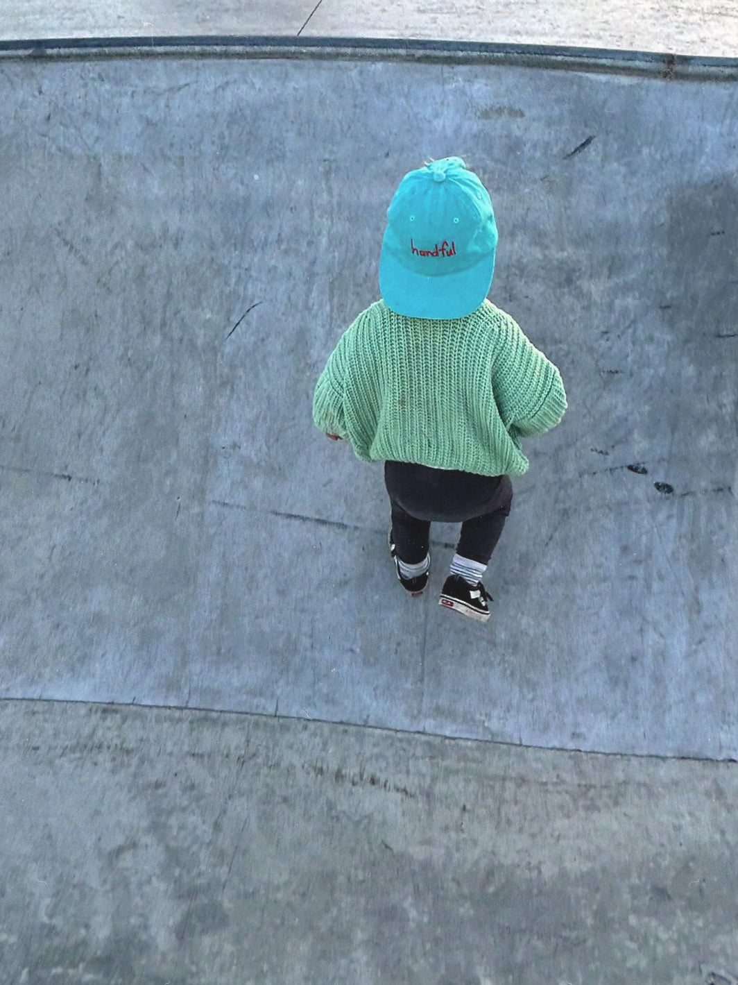 Aqua coloured cotton cap with “handful” text in red